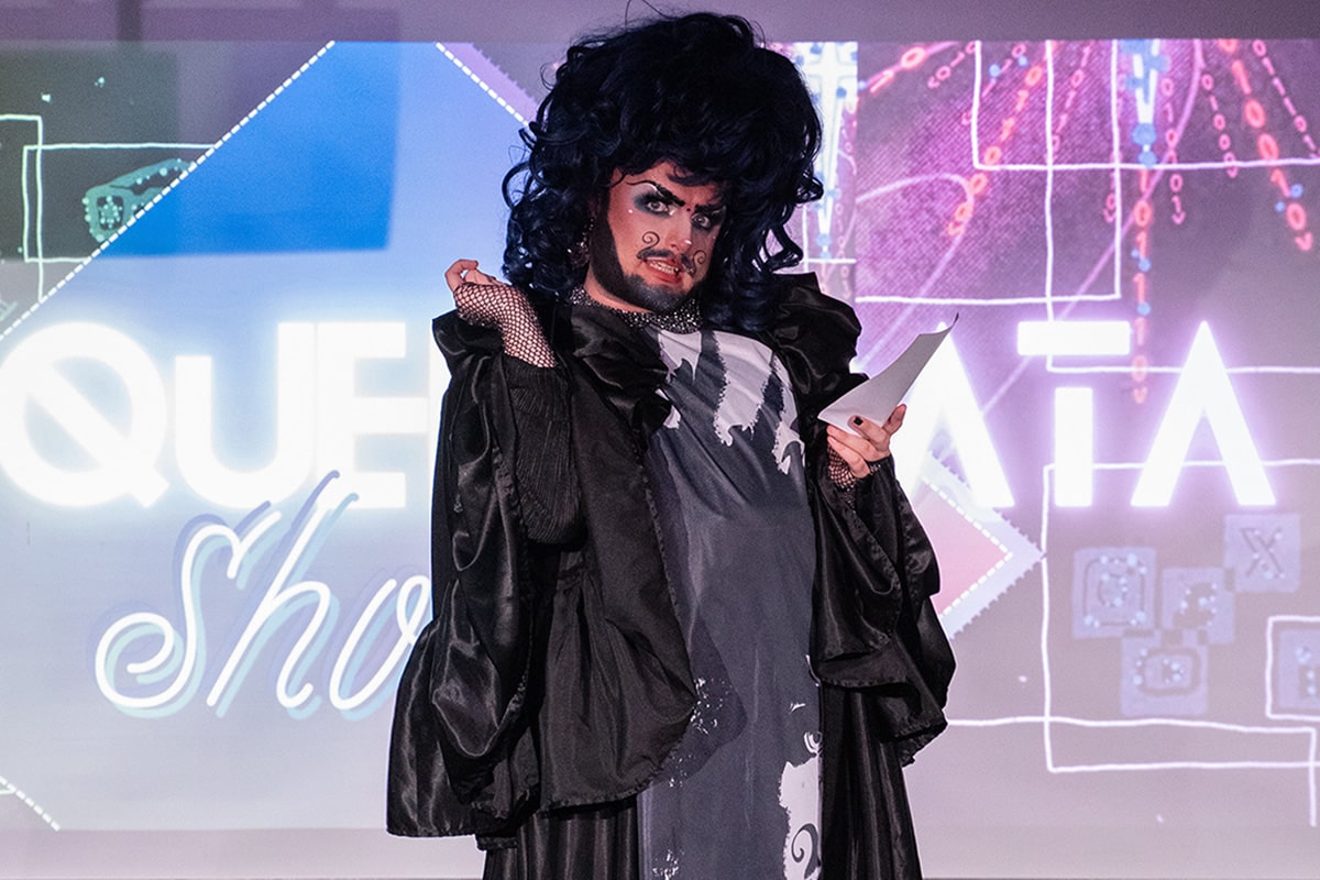 Drag icon presenting on stage at the The Queer Data Showcase